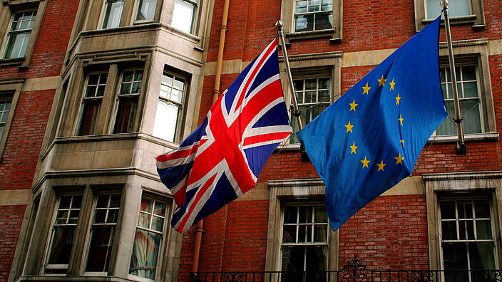 UK and EU flag in front of a building in the UK
