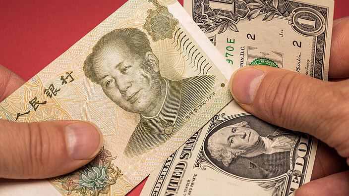 One Chinese yuan and One US dollar banknotes held in hand