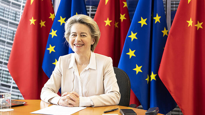Ursula von der Leyen in front of EU and Chinese flags