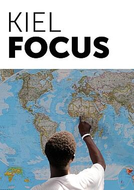 Cover Kiel Focus person points to a world map