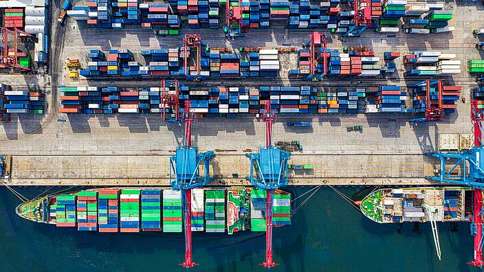Birds eye view of a ship in a harbor loaded with containers