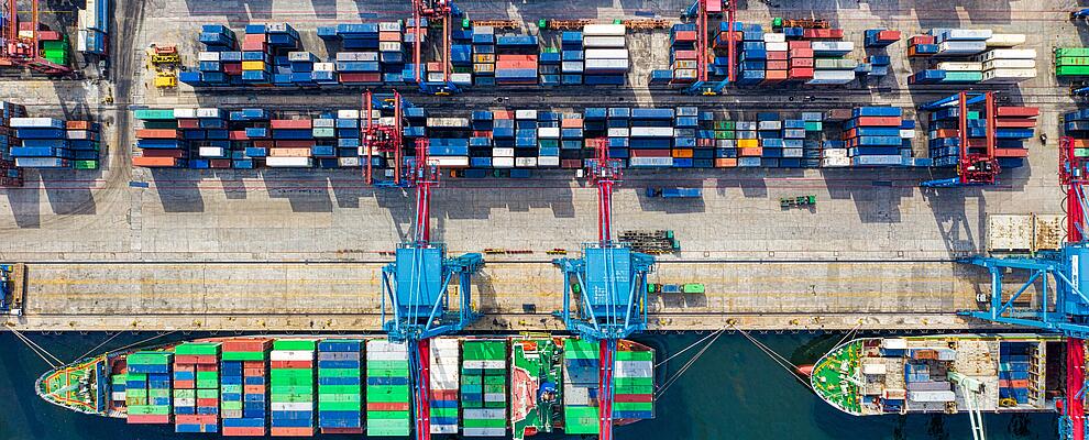 Birds eye view of a ship in a harbor loaded with containers