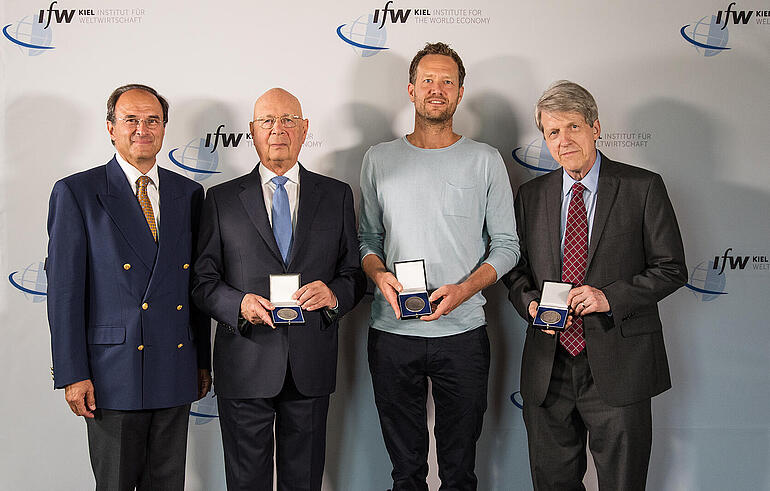 The three winners of the Global Economy Prize 2018 show their medals, Dennis J. Snower joins them for the picture