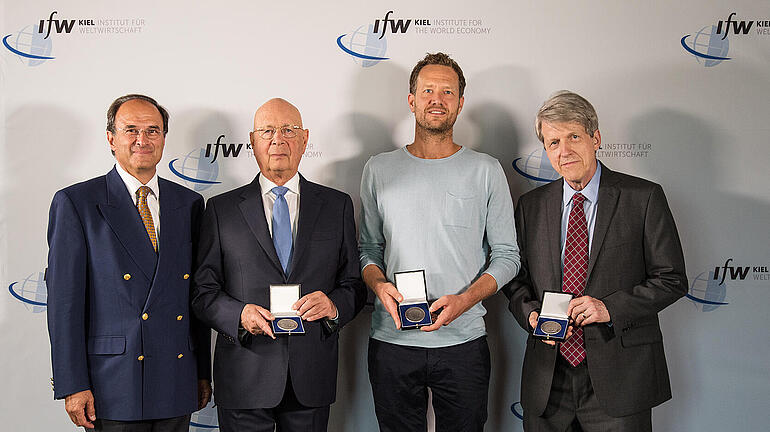 Die drei Gewinner des Weltwirtschaftlichen Preises 2018 zeigen ihre Medaillen. Zusätzlich auf dem Bild: IfW-Präsident Dennis Snower.