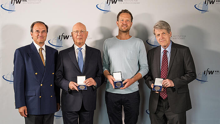 The three winners of the Global Economy Prize 2018 show their medals, Dennis J. Snower joins them for the picture