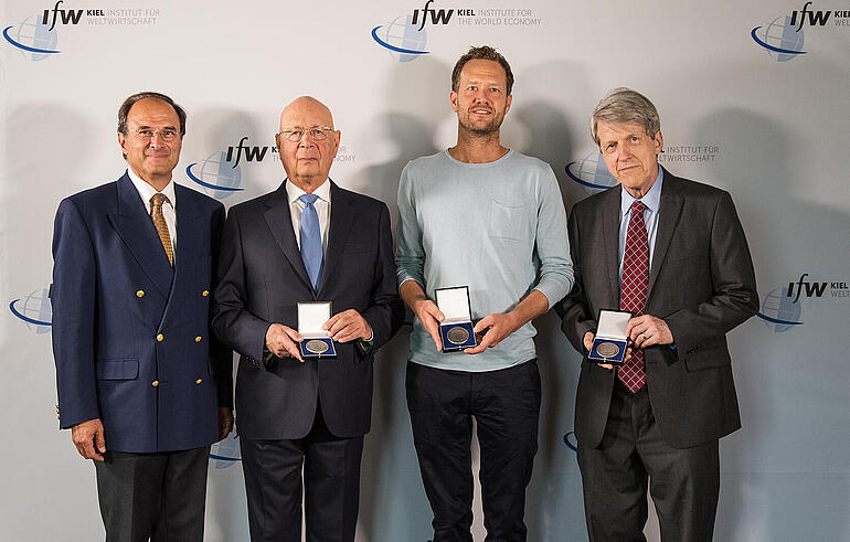The three winners of the Global Economy Prize 2018 show their medals, Dennis J. Snower joins them for the picture