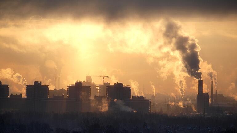 Many buildings and some smoking chimneys at a sunset, © Николай Григорьев - Fotolia.com