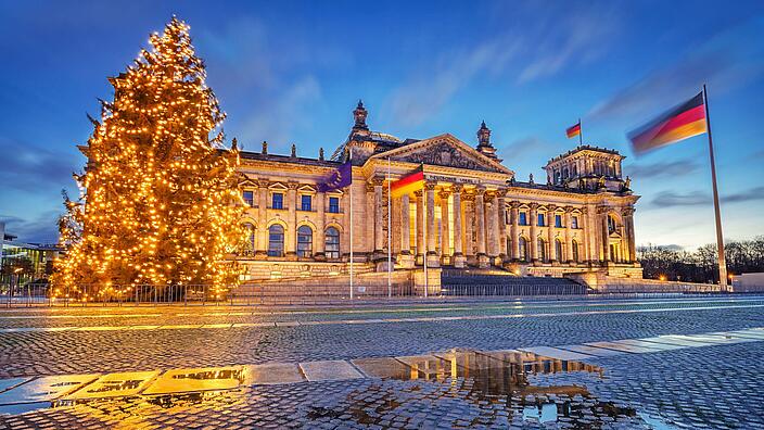 Berliner Reichstag bei Nacht mit erleuchtetem Weihnachtsbaum