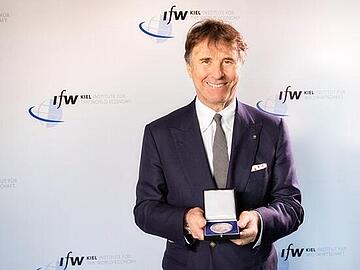 Brunello Cucinelli zeigt die Medaille, die er bei der Verleihung des Weltwirtschaftlichen Preises 2017 erhalten hat.