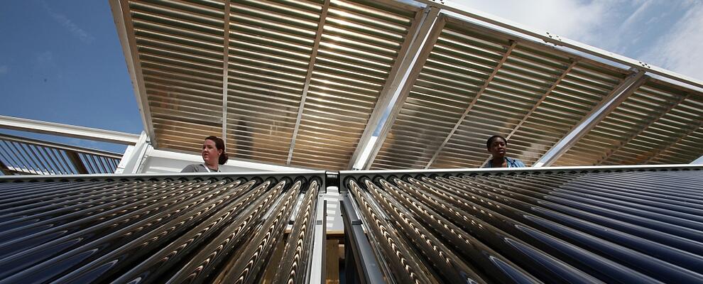 Two women inspect a solar panel 