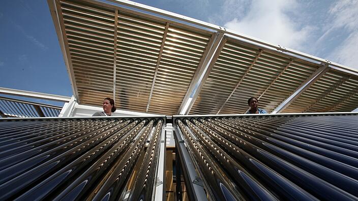 Two women inspect a solar panel 