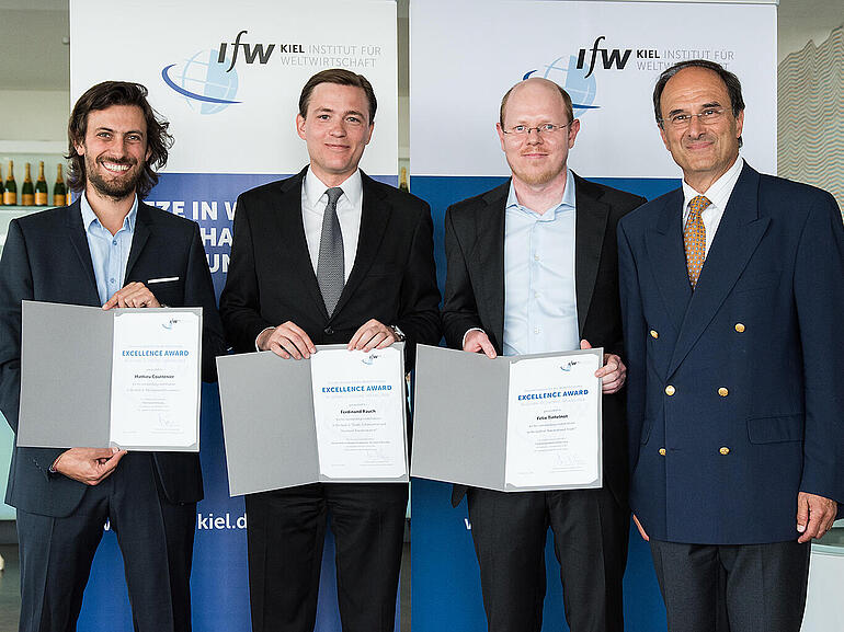 Drei der vier Excellence Award Preisträger zeigen ihre Urkunden. Mit auf dem Bild: IfW-Präsident Dennis Snower.