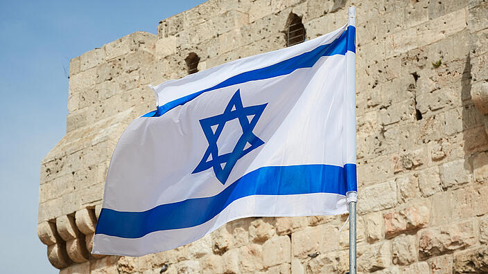 flag of Israel against the sky and the wall