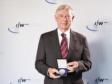 Horst Köhler shows the medal he received for the Global Economy Prize 2017.