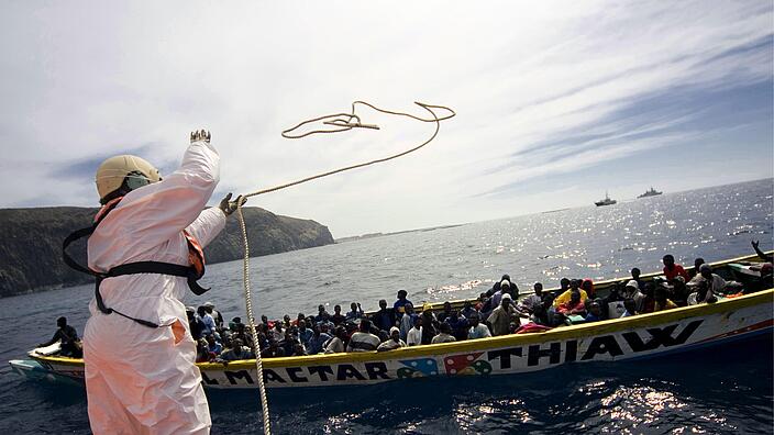 Die spanische Küstenwache fängt vor Teneriffa ein traditionelles Fischerboot mit afrikanischen Migranten ab.onal fishing boat carrying African migrants off the island of Tenerife in the Canaries.