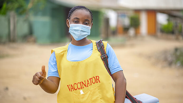 african lady in face mask with thumbs up-child vaccination concept