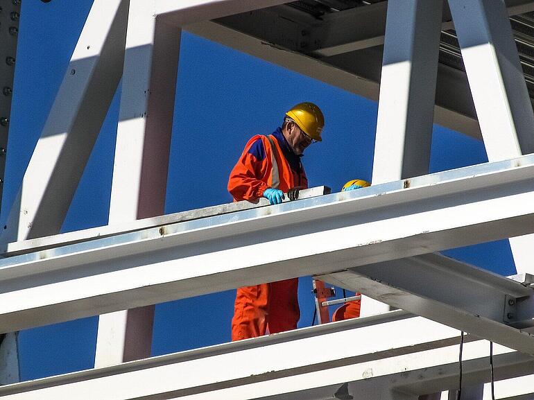 Construction worker standing on steel skeleton