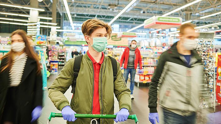 man in mask and protective gloves buying in shop at coronavirus epidemic