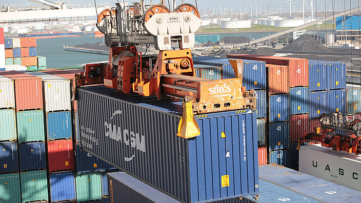 Containerhafen, ein Container wird von Kran transportiert