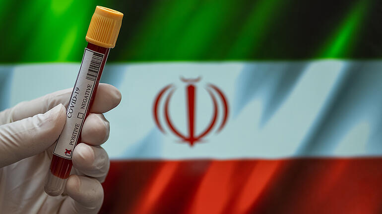 Flag of Iran with positive Covid-19 test tube