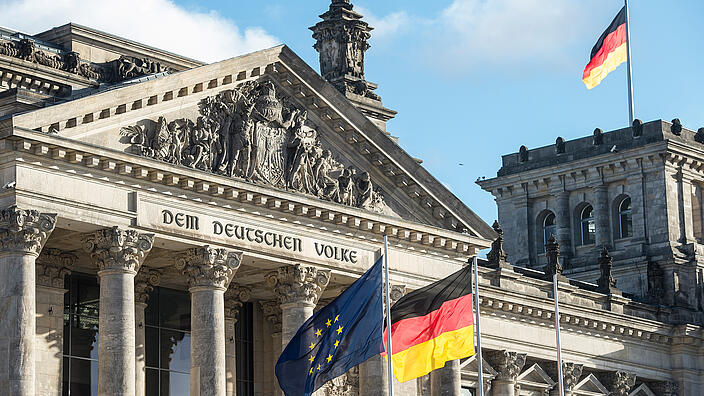 Deutscher Reichstag mit der deutschen und europäischen Flagge